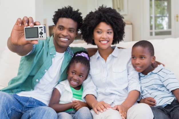 Família feliz tomando um selfie no sofá
