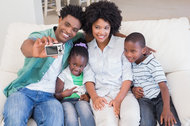 Família feliz tomando um selfie no sofá