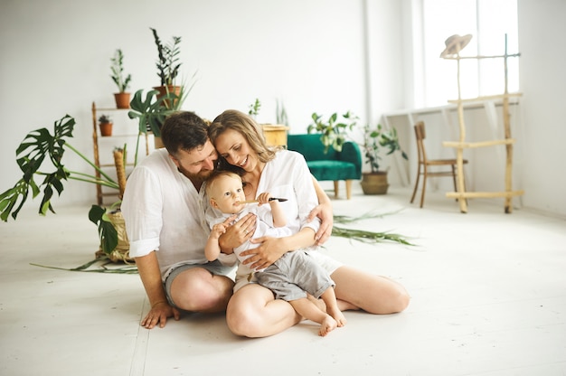 Familia feliz trabajando en casa. Trasplantar plantas con su hijo