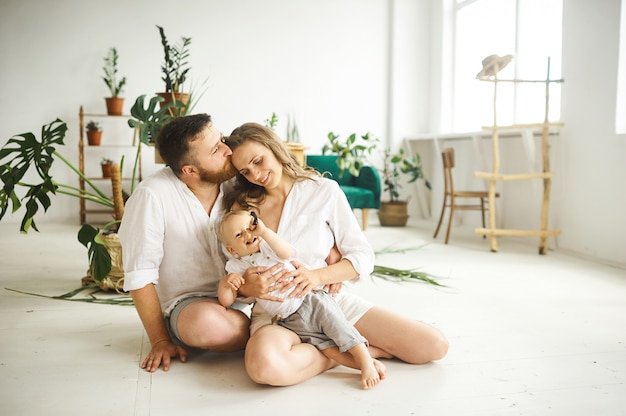 Família feliz trabalhando em casa. Transplantar plantas com seu filho