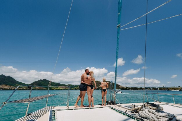 Una familia feliz en traje de baño se encuentra en un catamarán en el Océano Índico retrato de una familia en un yate en el arrecife de coral de la isla Mauricio