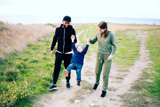 Familia feliz de tres divirtiéndose juntos al aire libre