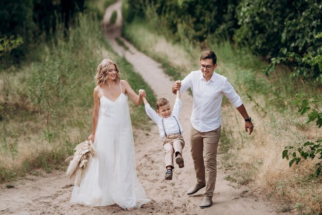 Família feliz três pai mãe e filho em uma caminhada