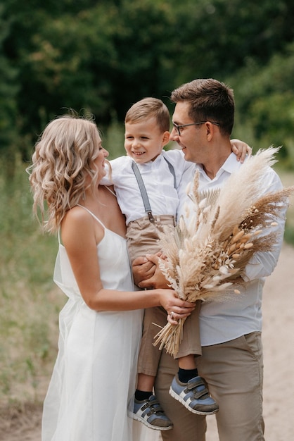 Família feliz três pai mãe e filho em uma caminhada