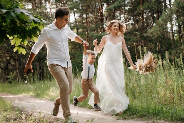 Família feliz três pai mãe e filho em uma caminhada