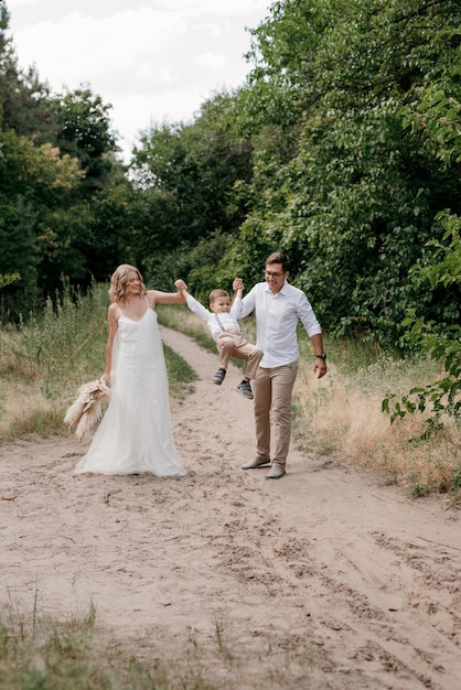 Familia feliz tres papá mamá e hijo en un paseo