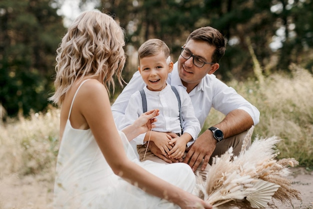 Familia feliz tres papá mamá e hijo en un paseo