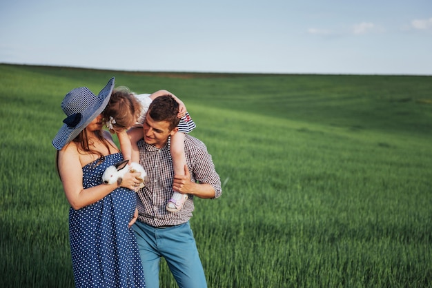 Familia feliz de tres personas abrazándose en las calles