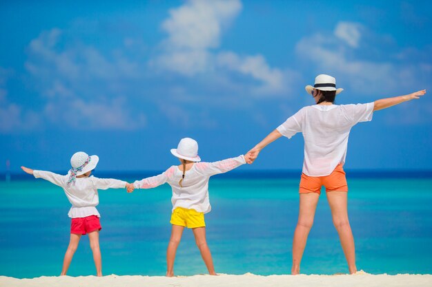 Familia feliz de tres en tropical playa blanca