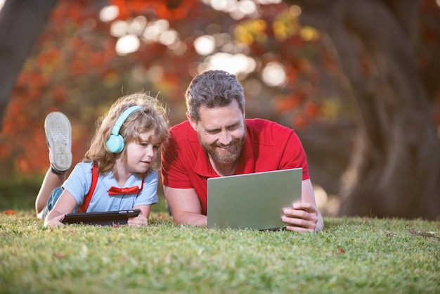 Família feliz usa laptop para videochamada ou aula ouve música em fones de ouvido no blog da família do parque