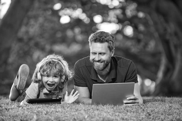 Família feliz usa laptop para videochamada ouça música em fones de ouvido na educação do parque on-line