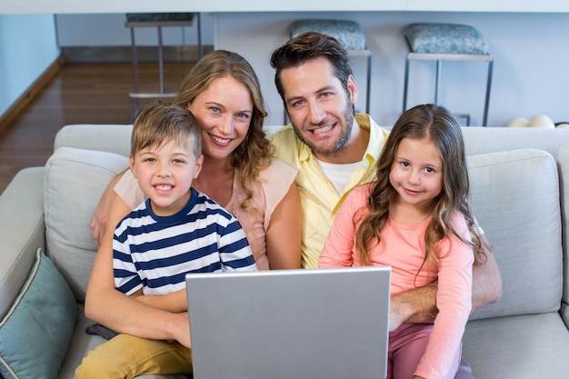 Familia feliz usando la computadora portátil juntos