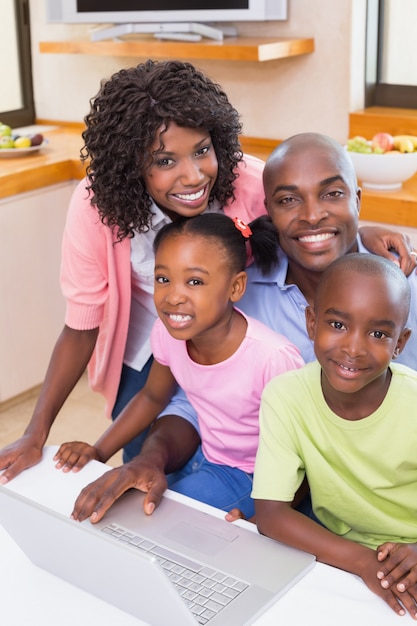 Familia feliz usando la computadora portátil juntos