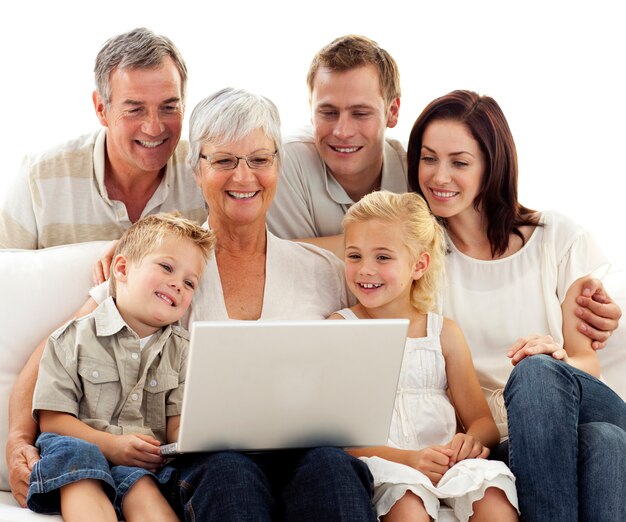 Familia feliz usando una computadora portátil en la sala de estar