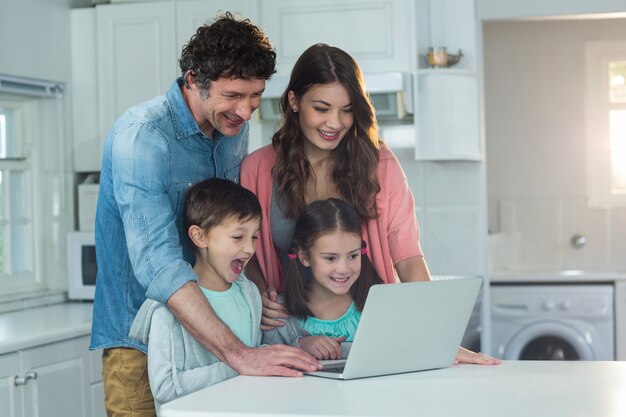 Foto família feliz usando laptop