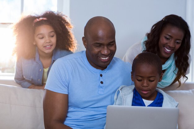 Família feliz usando laptop