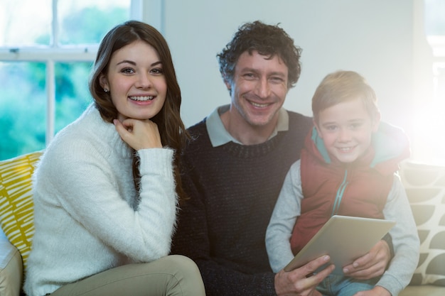 Família feliz usando tablet digital