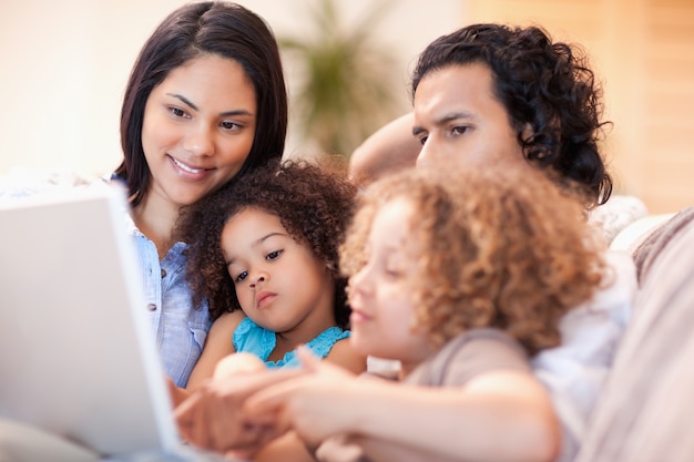 Familia feliz, usar la computadora portátil, juntos