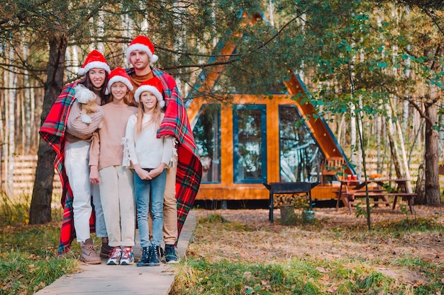 Familia feliz en vacaciones de Navidad. Padre con hijos envueltos en una manta