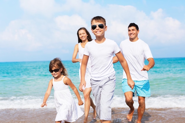 Familia feliz de vacaciones en la playa tropical