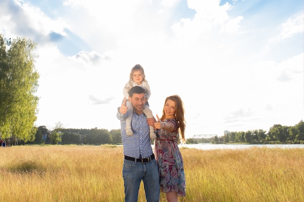 La familia feliz de verano al aire libre