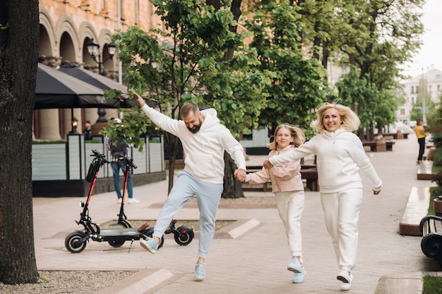 Una familia feliz vestida de blanco camina por la ciudad.