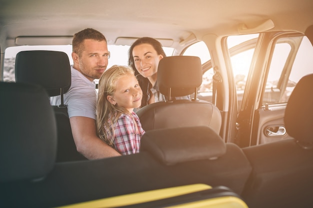 Familia feliz en un viaje por carretera en su coche.