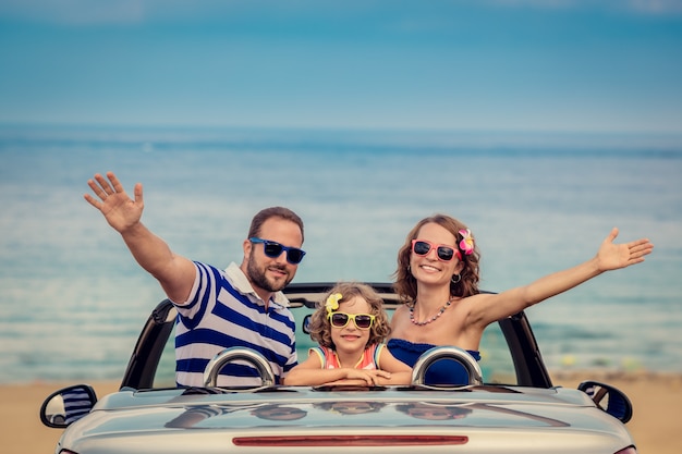 Familia feliz viaje en coche al mar Gente divirtiéndose en cabriolet Concepto de vacaciones de verano