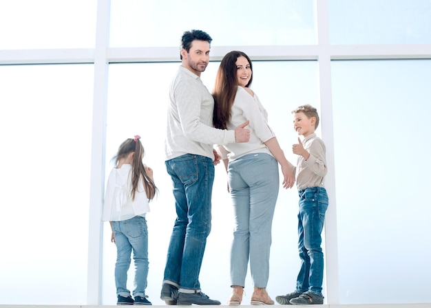 Família feliz vista traseira ao lado da grande janela