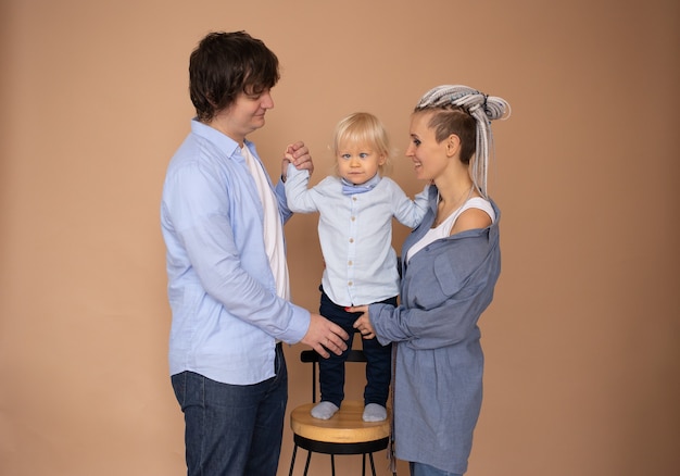 Familia feliz vistiendo ropa casual aislado pared beige