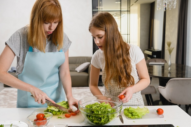 Família feminina fazendo salada em casa juntos