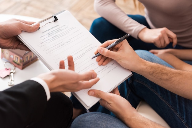 Familia firma contrato de compra de vivienda nueva.