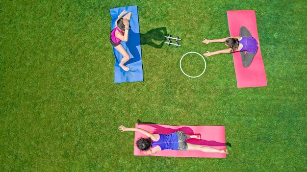 Familia fitness y deporte al aire libre grupo de chicas activas haciendo ejercicio en el parque mujeres ejercicio