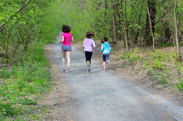 Família fitness e esporte, mãe feliz ativa e crianças correndo ao ar livre, correndo na floresta