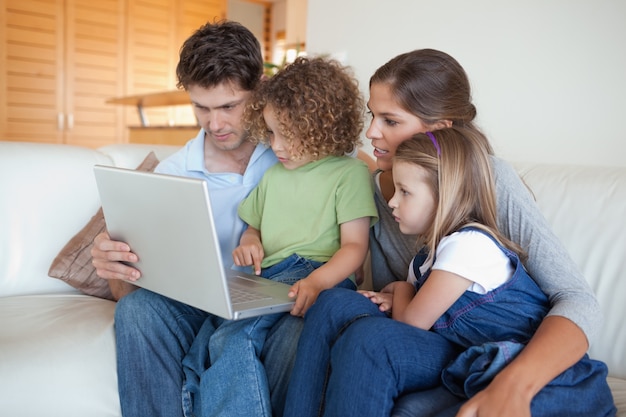 Foto família focalizada usando um laptop