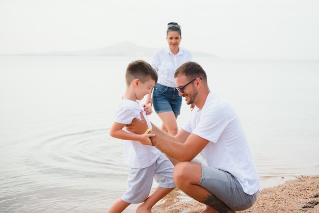 Família fofa e feliz se divertindo na praia