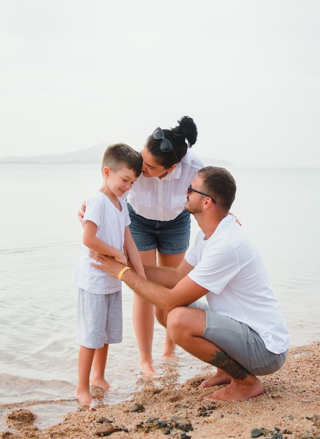 Família fofa e feliz se divertindo na praia