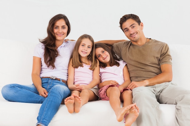 Família fofa sentado em um sofá na sala de estar