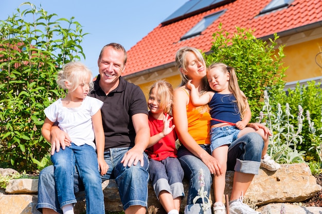 Familia frente a casa o casa