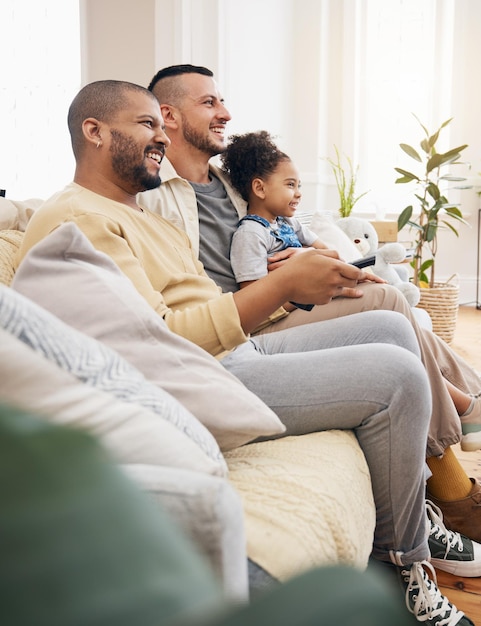 Família gay assistindo televisão e filmes em casa sofá com uma criança para streaming entretenimento ou diversão homens LGBTI ou pais e menina criança relaxar com controle remoto para assinatura programa de cabo e felicidade