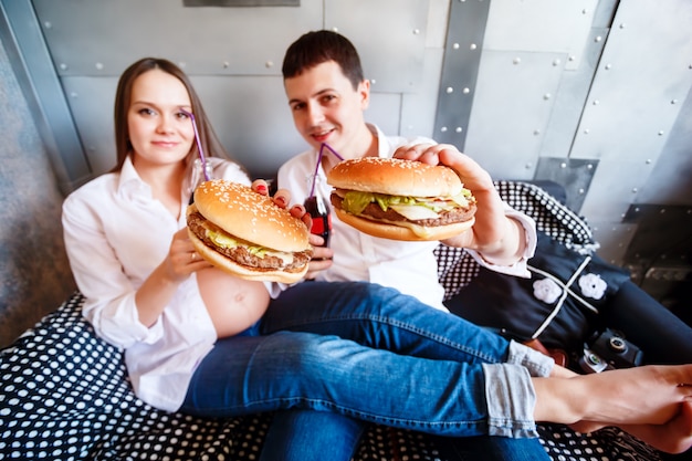 Foto família grávida feliz comendo fast-food