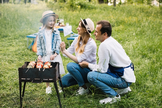 Foto familia haciendo una barbacoa en la naturaleza