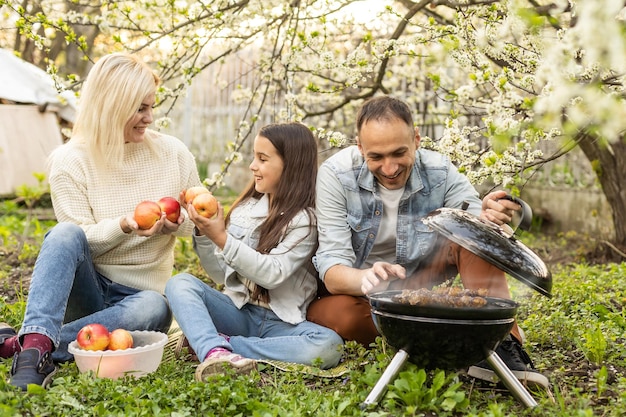 Familia haciendo una barbacoa en su jardín.