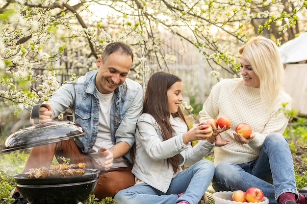 Familia haciendo una barbacoa en su jardín.