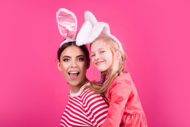 Familia hermana de Pascua. Concepto festivo de felices fiestas. Niñas jugando con orejas de conejo. Búsqueda de huevos tradicional fiesta de primavera. Disfraz de conejo.