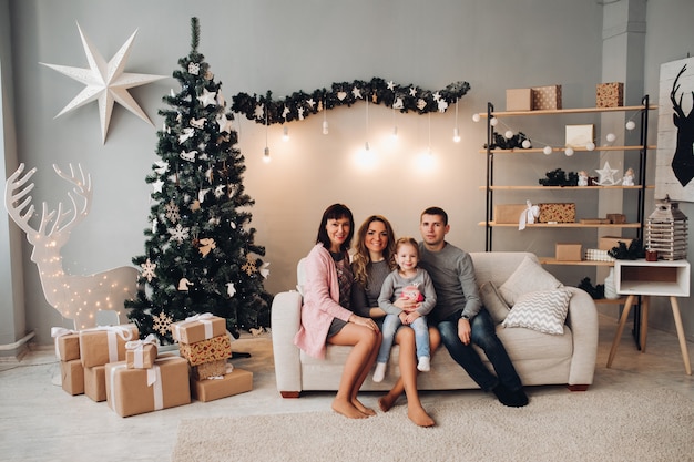 Familia en hermosa habitación decorada para Navidad.