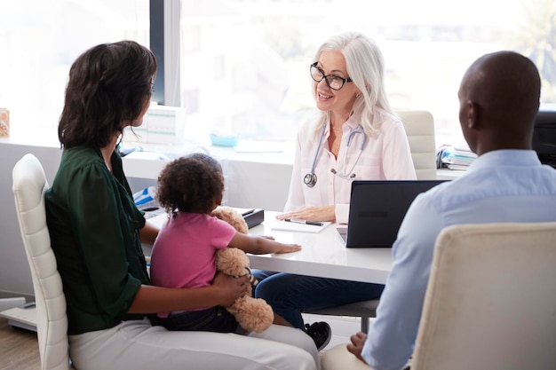 Familia con hija en consulta con el médico en la oficina