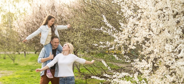 Familia con hija juegan juntos en el jardín en primavera