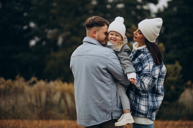 Familia con hija pequeña juntos en clima otoñal divirtiéndose