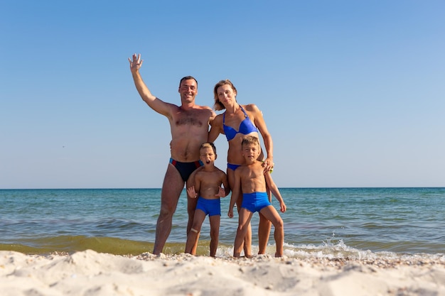 Familia con hijos gemelos divirtiéndose en la playa